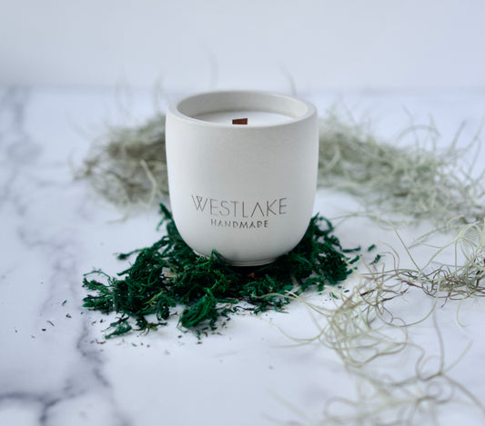 Westlake Handmade concrete candle on a white marble surface with moss.