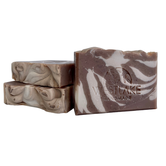 Three bars of Westlake Handmade soap with a marbled design on a white background