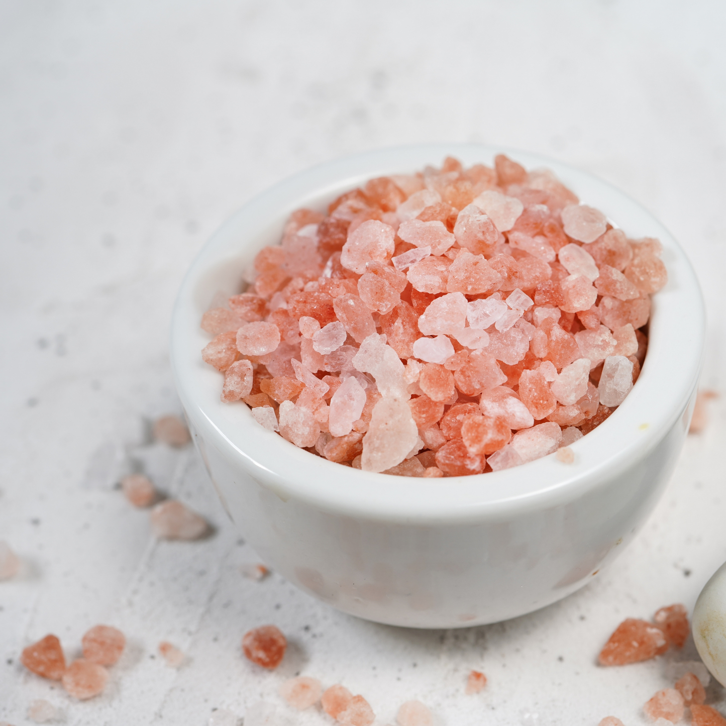 Pink Himalayan salt in a white bowl on a white background