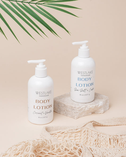 Two bottles of Westlake Handmade body lotion on a neutral background with a leaf decoration.