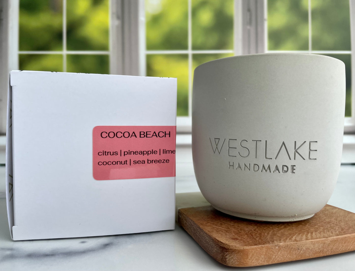 Westlake Handmade concrete candle next to a product packaging box on a marble surface.