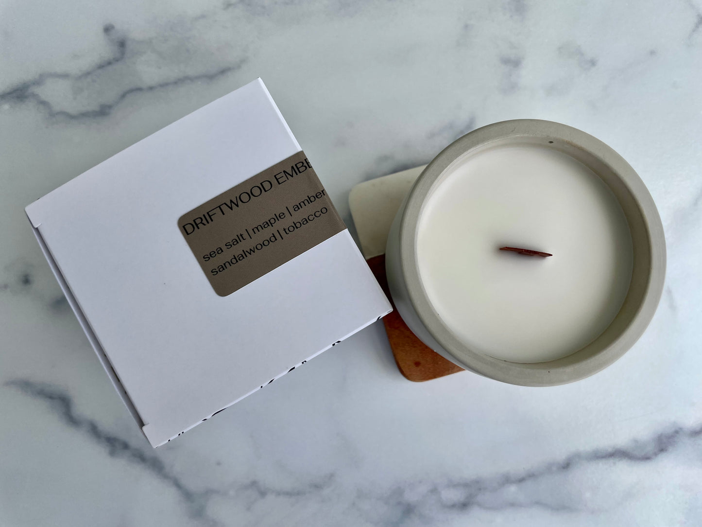 Westlake Handmade concrete candle from the top with packaging on a marble surface
