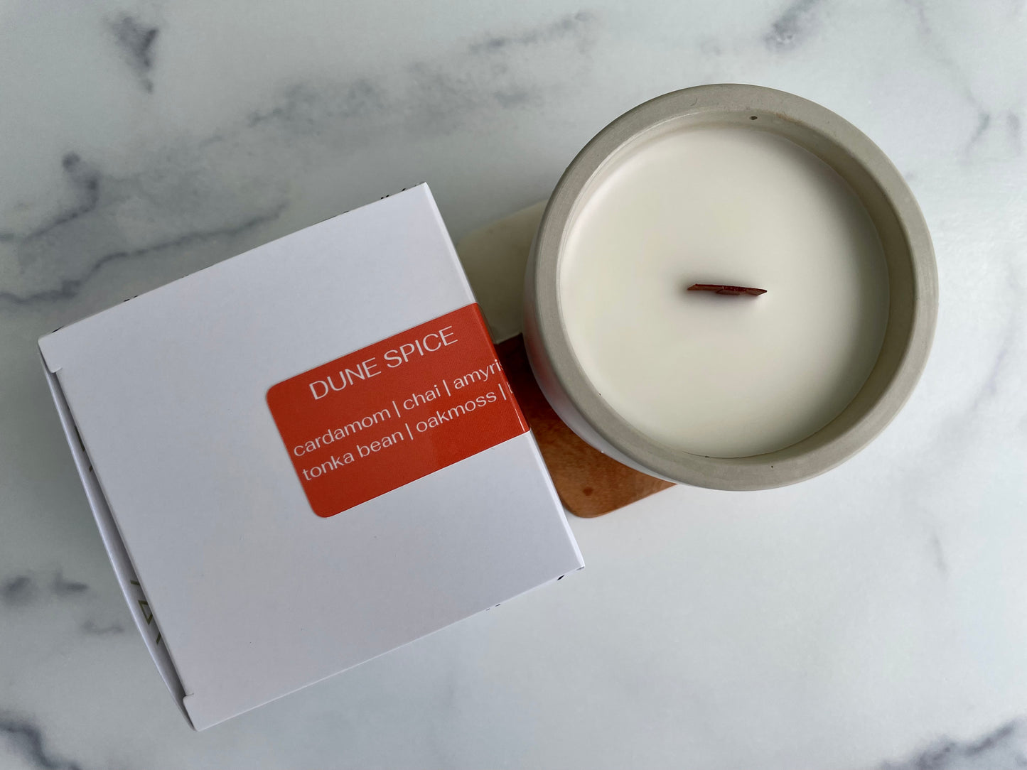 Westlake Handmade concrete candle with a 'Dune Spice' label on a marble surface