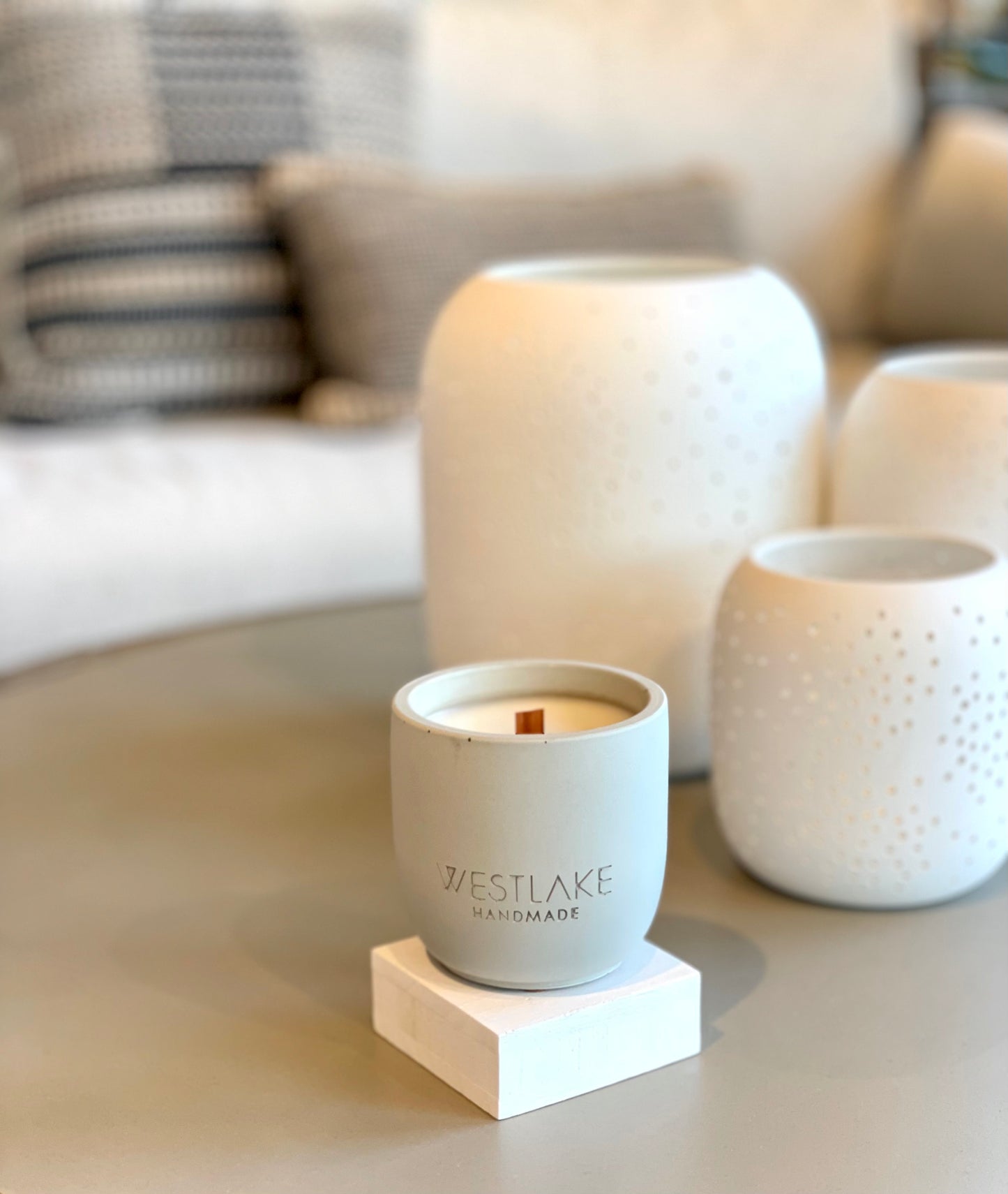Westlake handmade candle on a table with a blurred sofa in the background