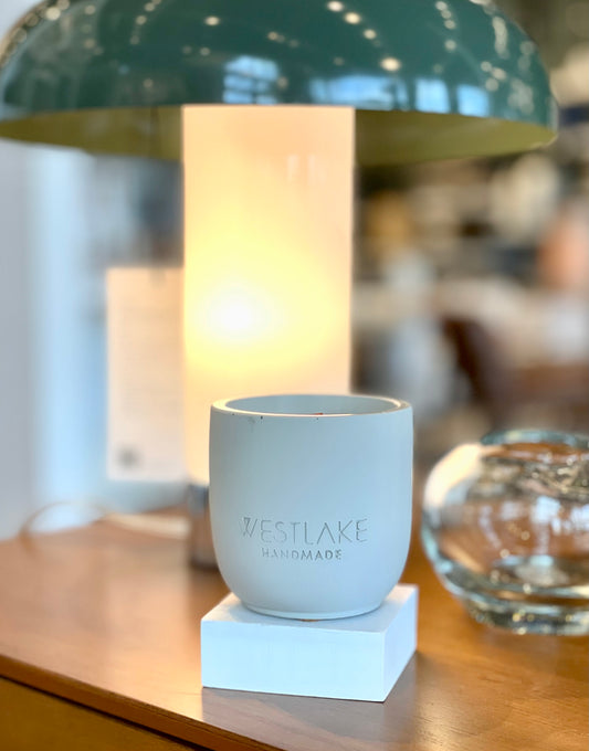 Westlake Handmade concrete candle on a wooden surface with a blurred background