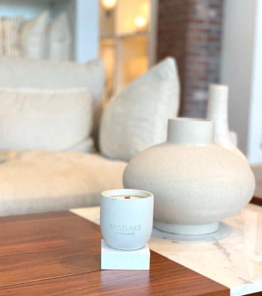 Westlake Handmade concrete andle and decorative vase on a coffee table with a blurred background of a living room.