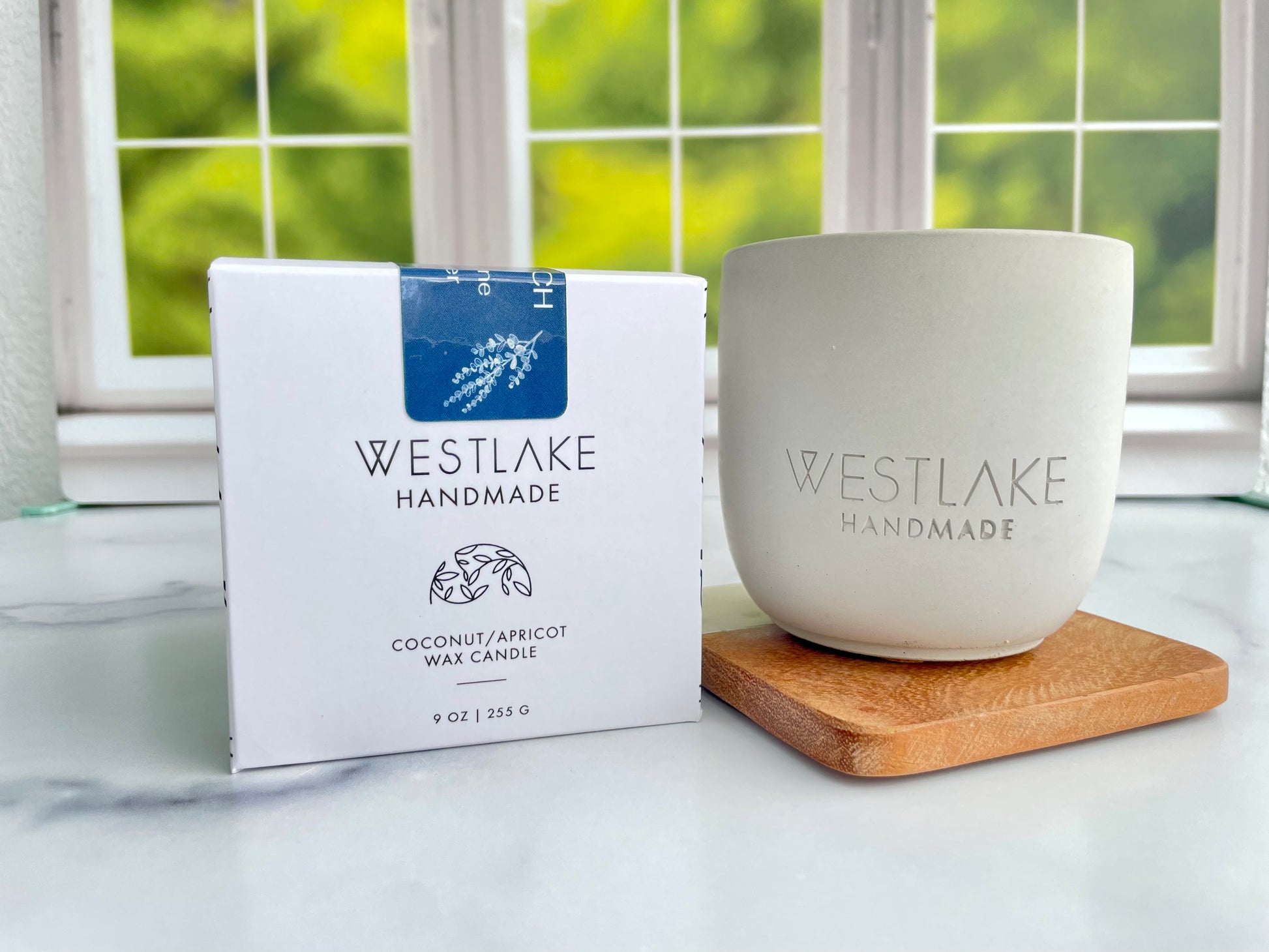 Westlake Handmade candle and packaging on a marble surface with a window in the background