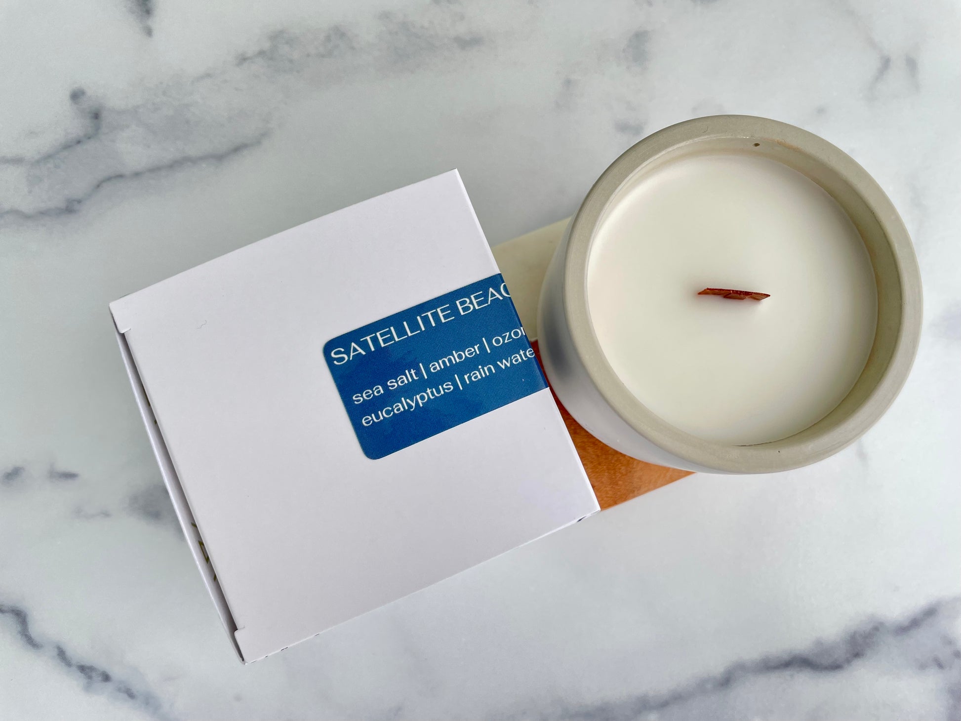 Westlake Handmade concrete candle in a white container with a label on a marble surface