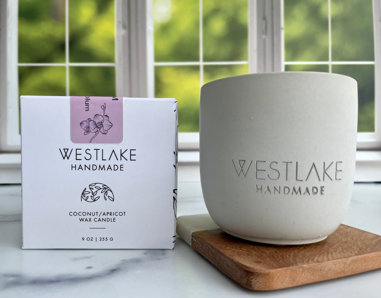 Westlake Handmade candle and packaging on a marble surface with a window in the background