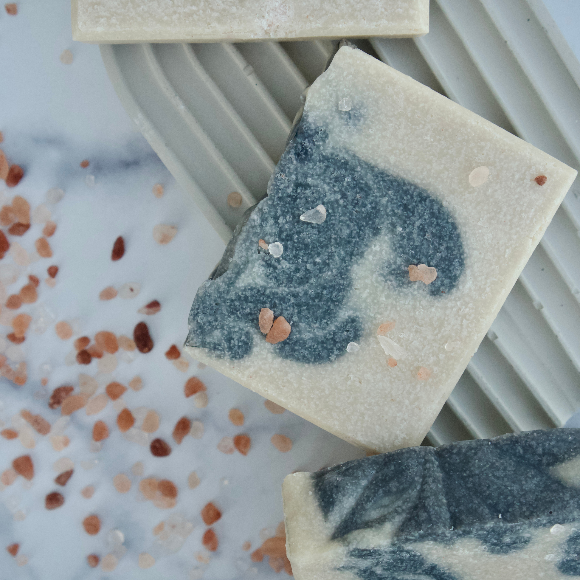 Marble-patterned soap bars with blue and gray swirls on a white surface.